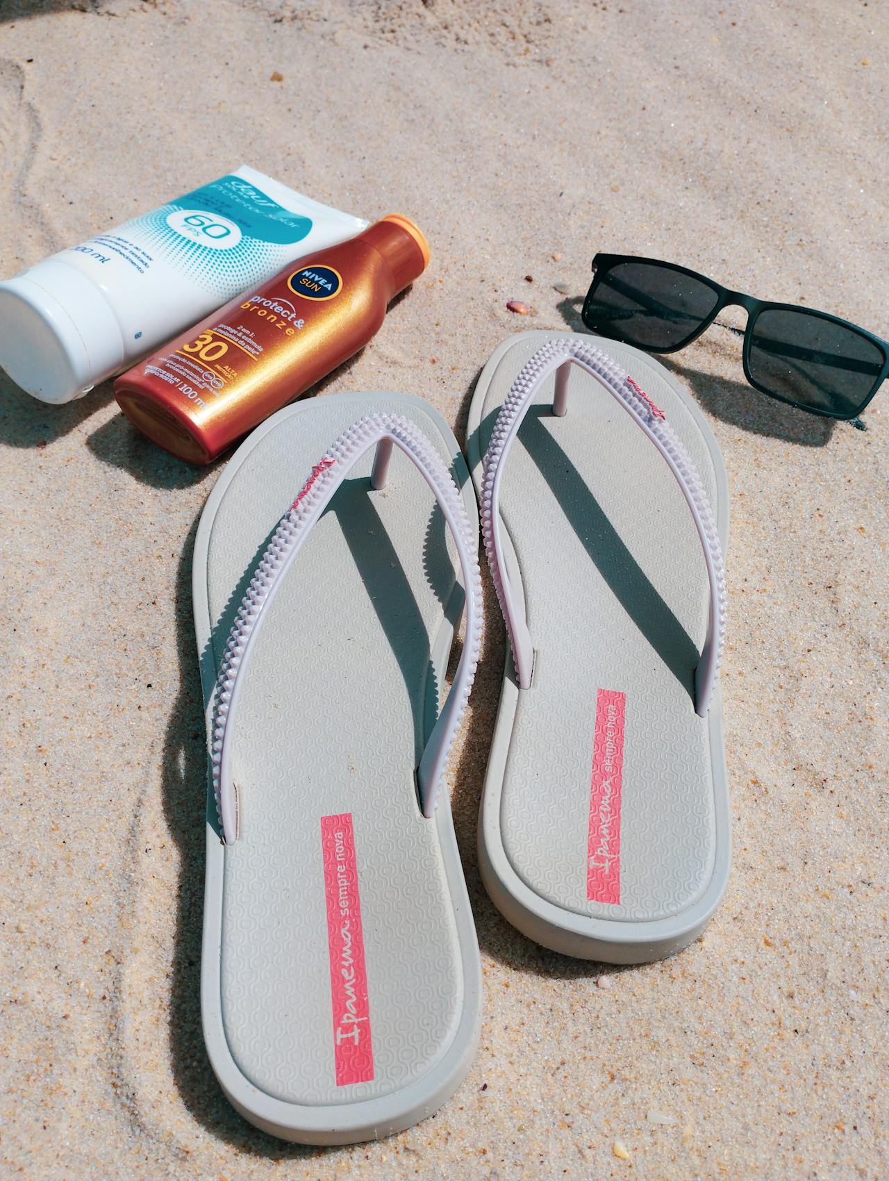 Косметические средства для летнего ухода на фоне пальмовых листьев